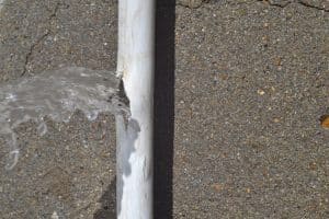 Visible water leak from a cracked pipe requiring plumbing repair.